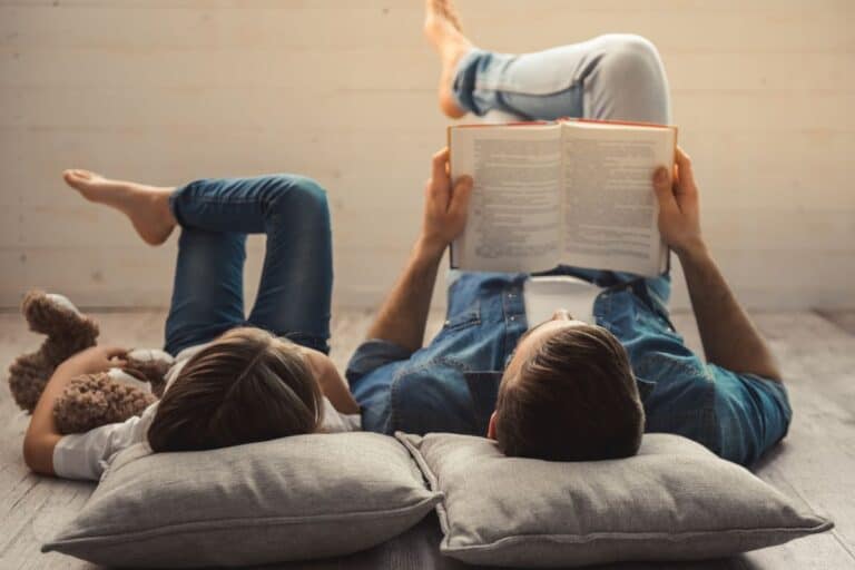 father and son reading books together.