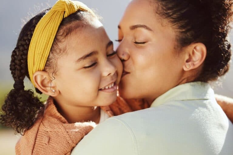 mom kissing her young daughter- concept of being a mom