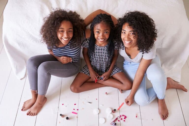 Group of girls sitting on the floor smiling.