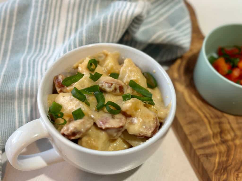 cheesy potatoes and sausage in white bowl