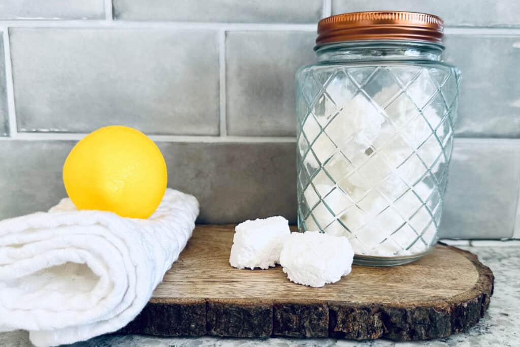 Jar of toilet tabs on a wooden slab on countertop