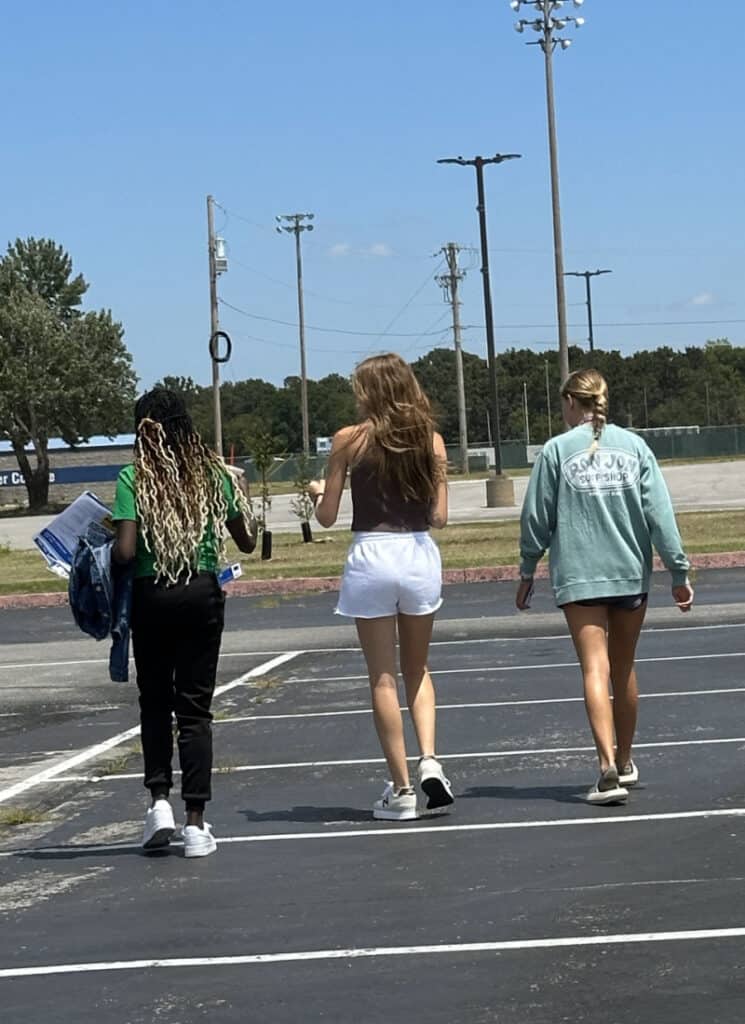 College dropoff day- three students walking across parking lot after dropoff.